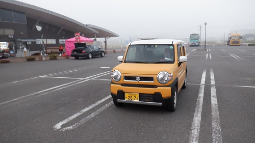 霧に包まれている道に駅と愛車