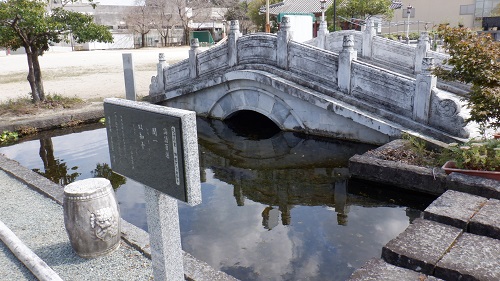 孔子公園内にある橋が架かった池と論語説明看板